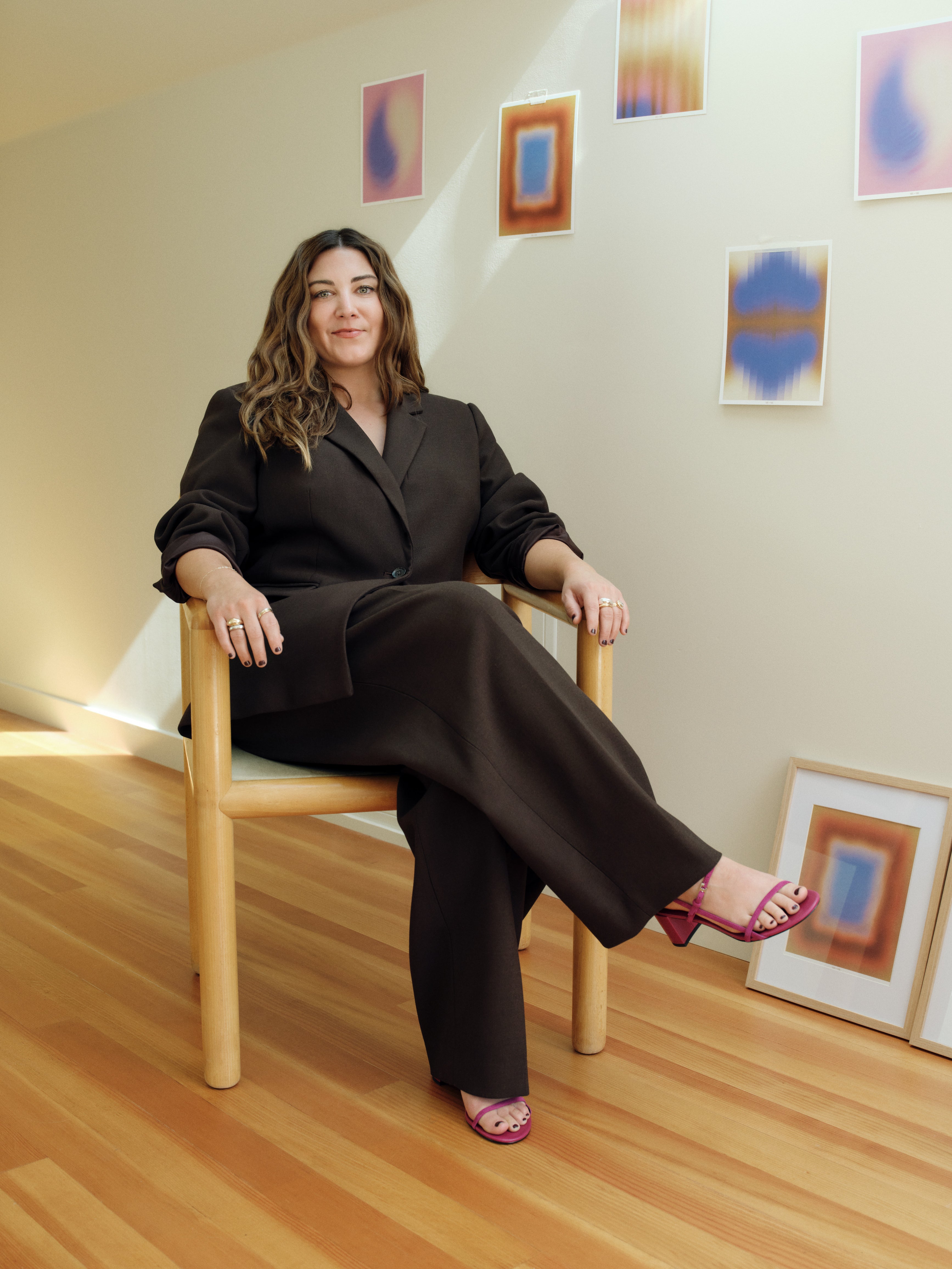 Shana Rehwald, founder of Me-est Me sitting in front of Me-est Me's art prints